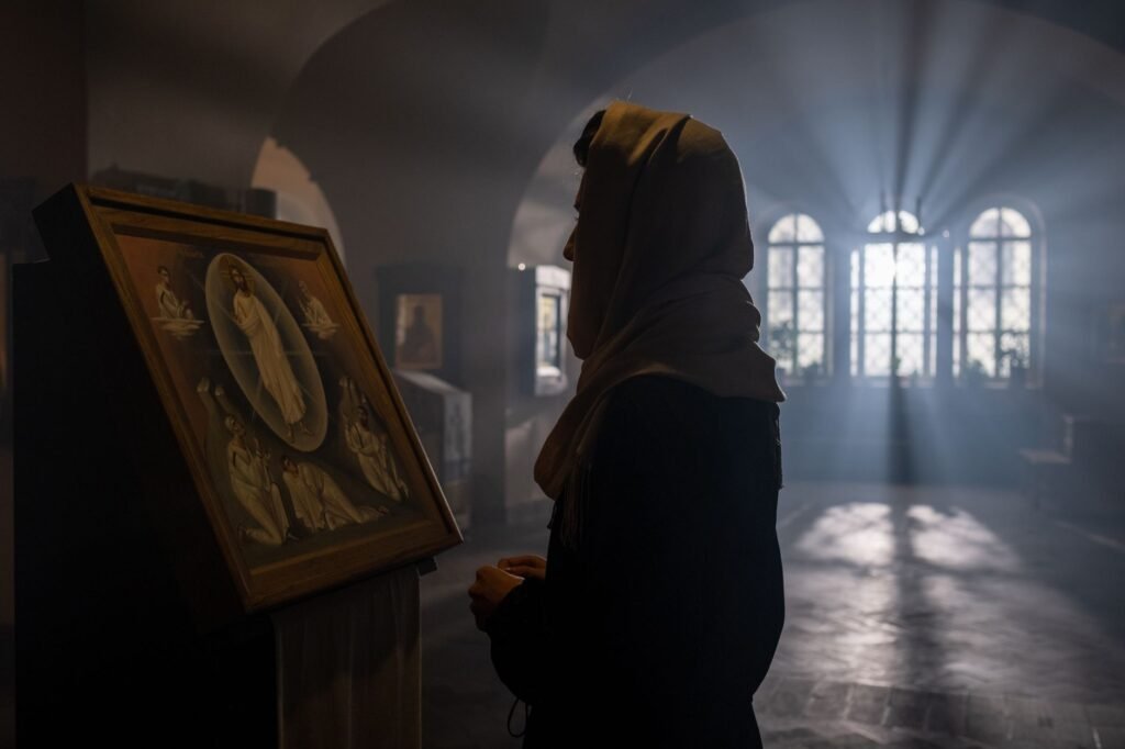 A woman in prayer by a window, seeking God's guidance and wisdom