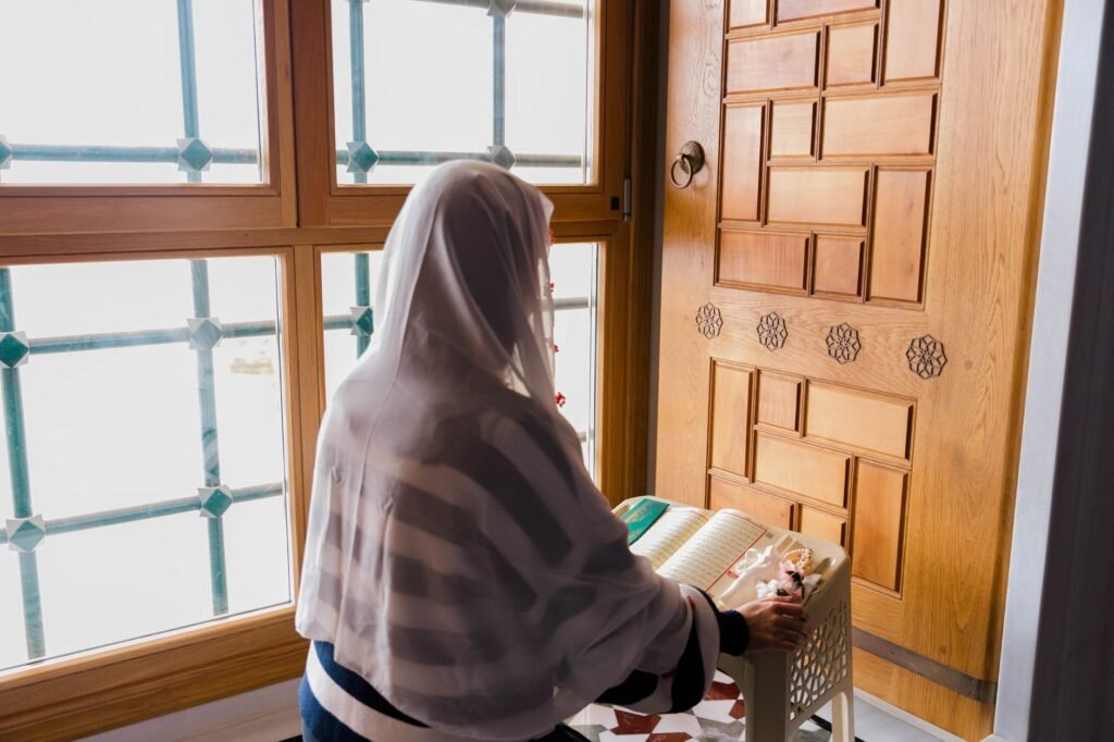 A woman praying by the window, illustrating the power of prayer in seeking strength