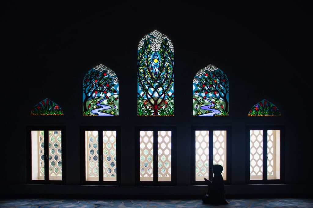 A woman praying by the window, seeking strength and courage in her faith